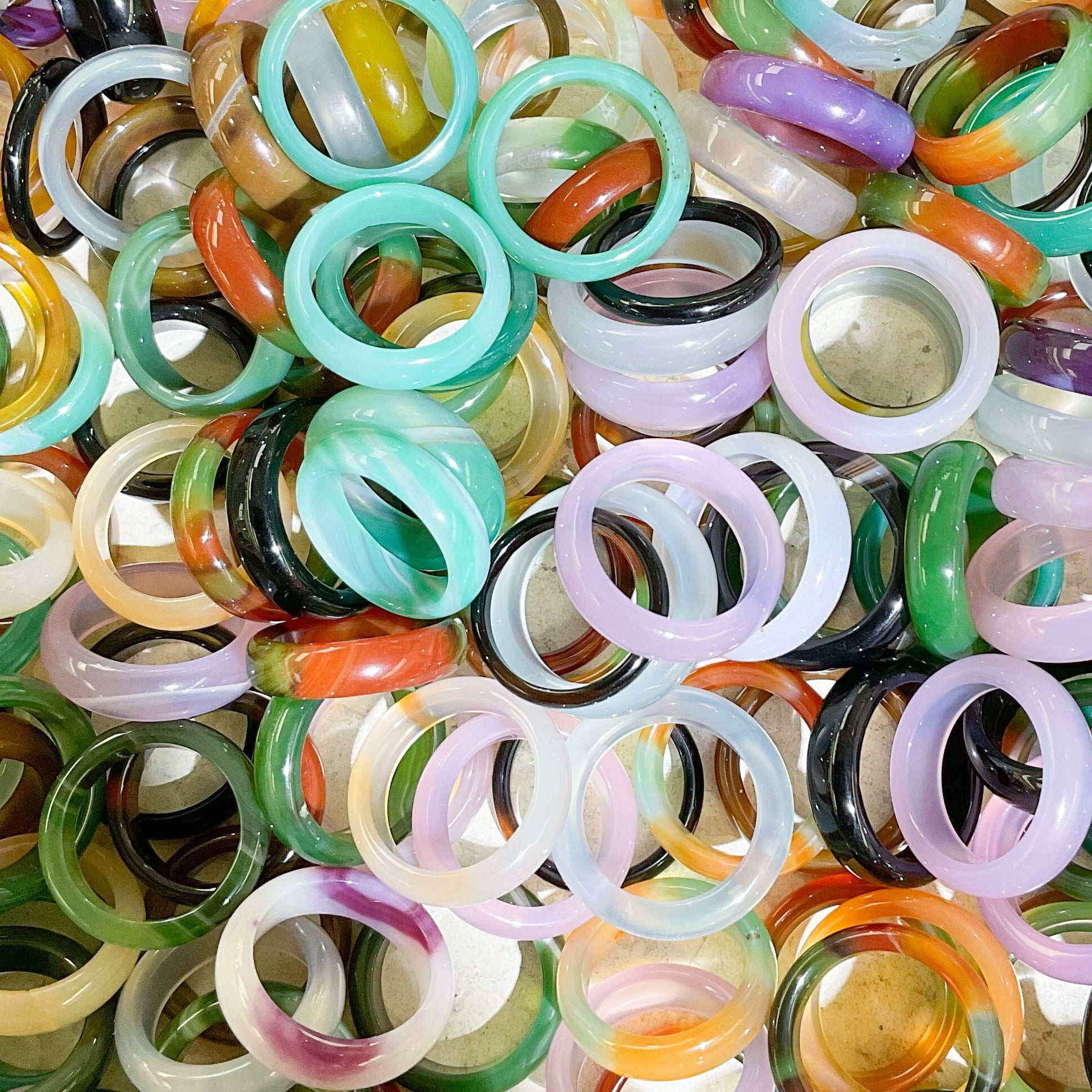 assortment of multicolor band stone rings in a pile