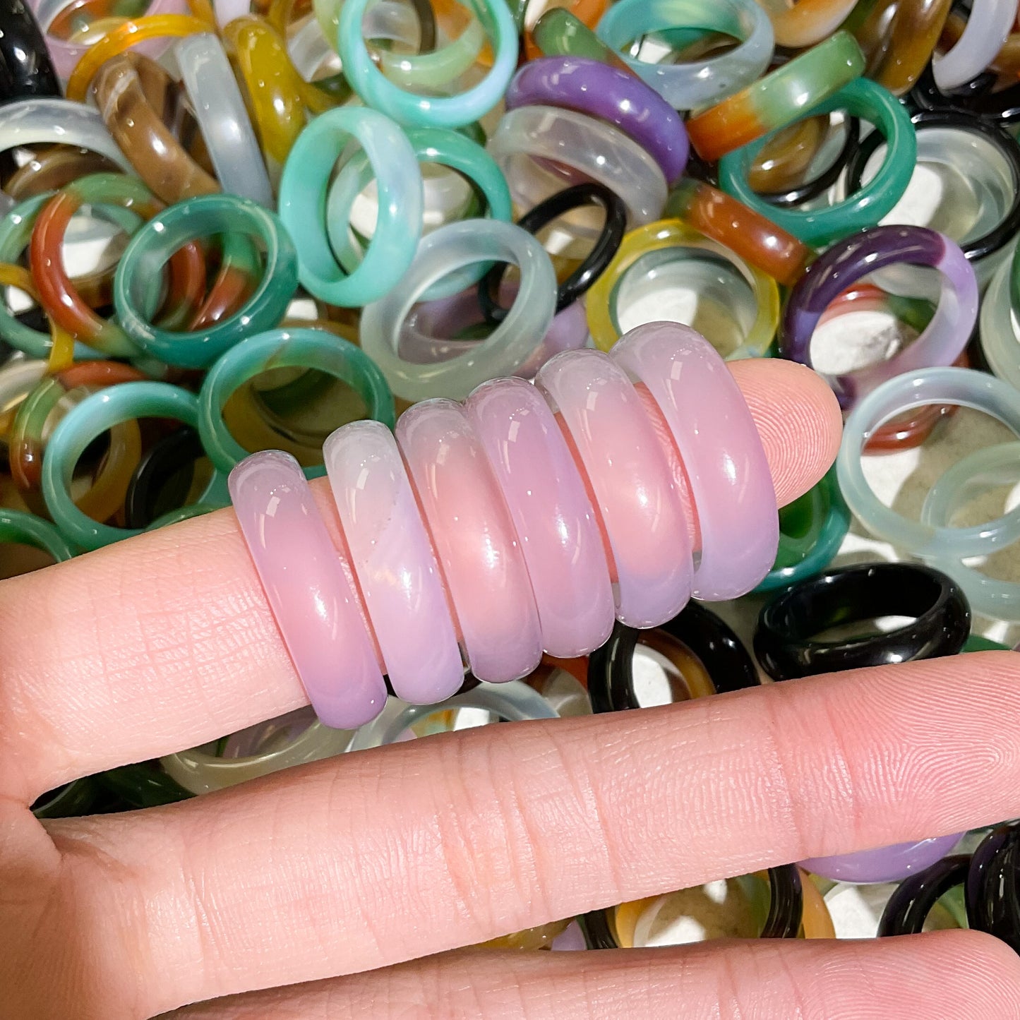 pink agate banded smooth rings stacked and modeled on finger