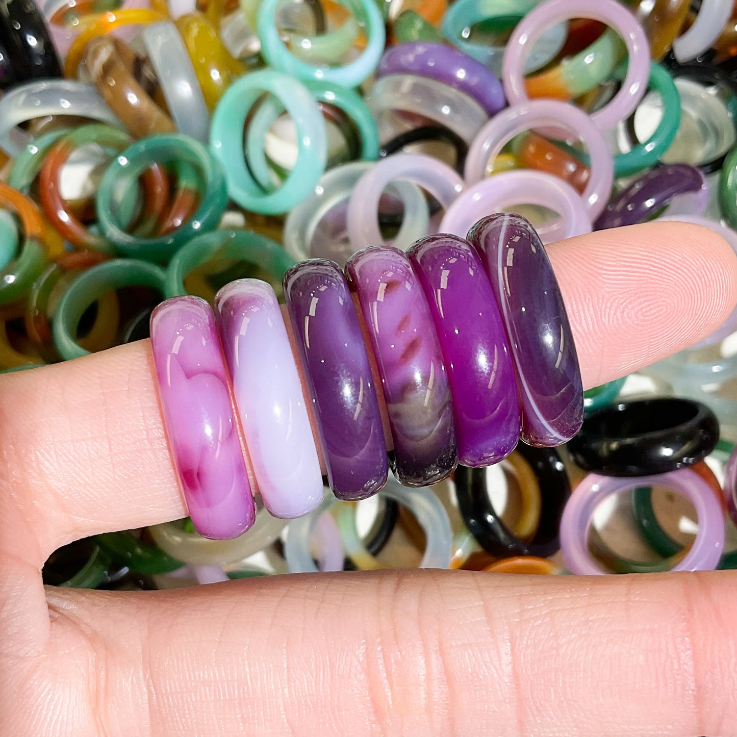 purple and white banded rings modeled on finger